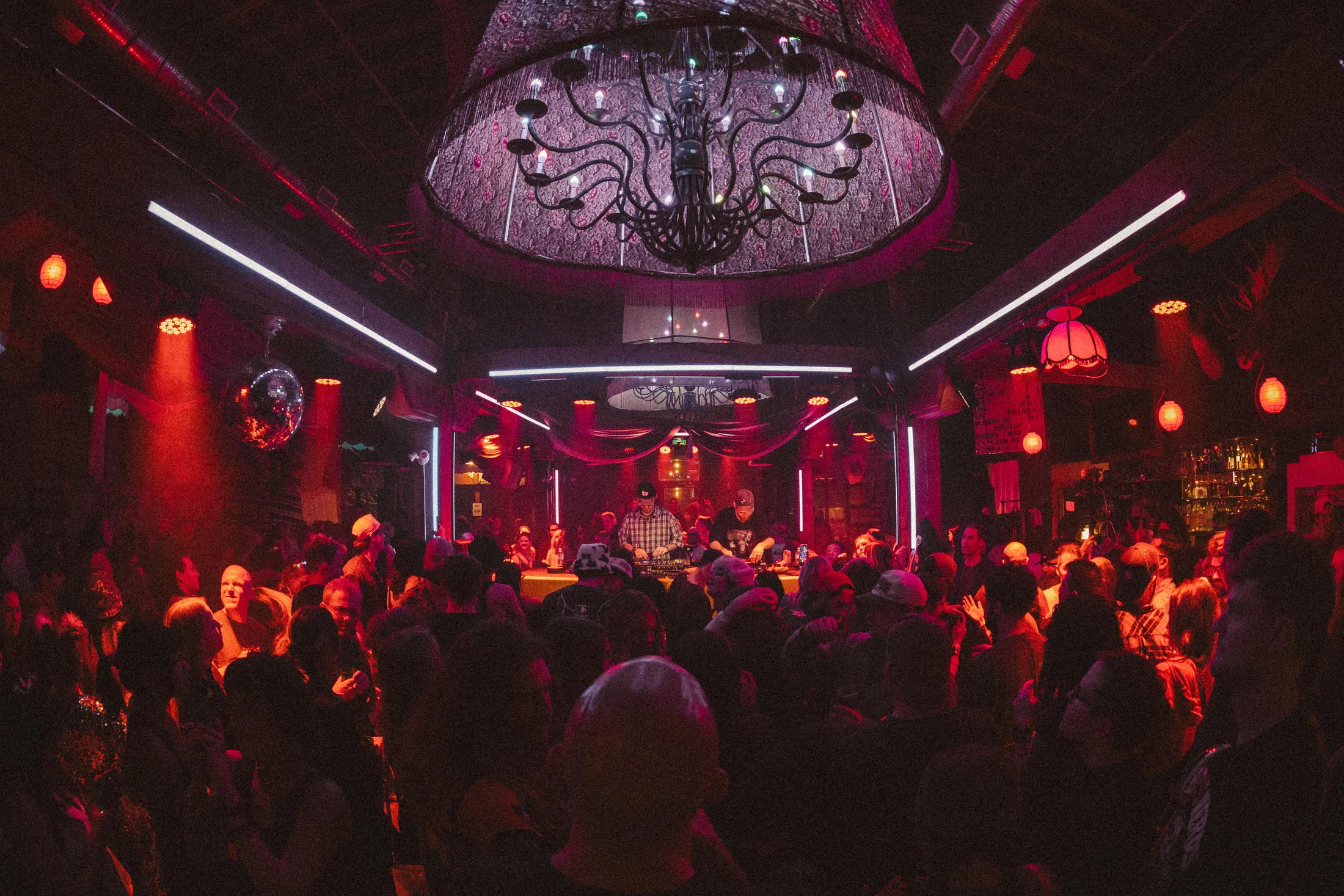 The main room at BNA Brewing Co. packed under the chandelier, DJ at the back